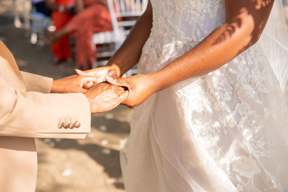 Wedding photoshoot at sunset on the beach in Riu Place. Detail shots of hands and wedding dress