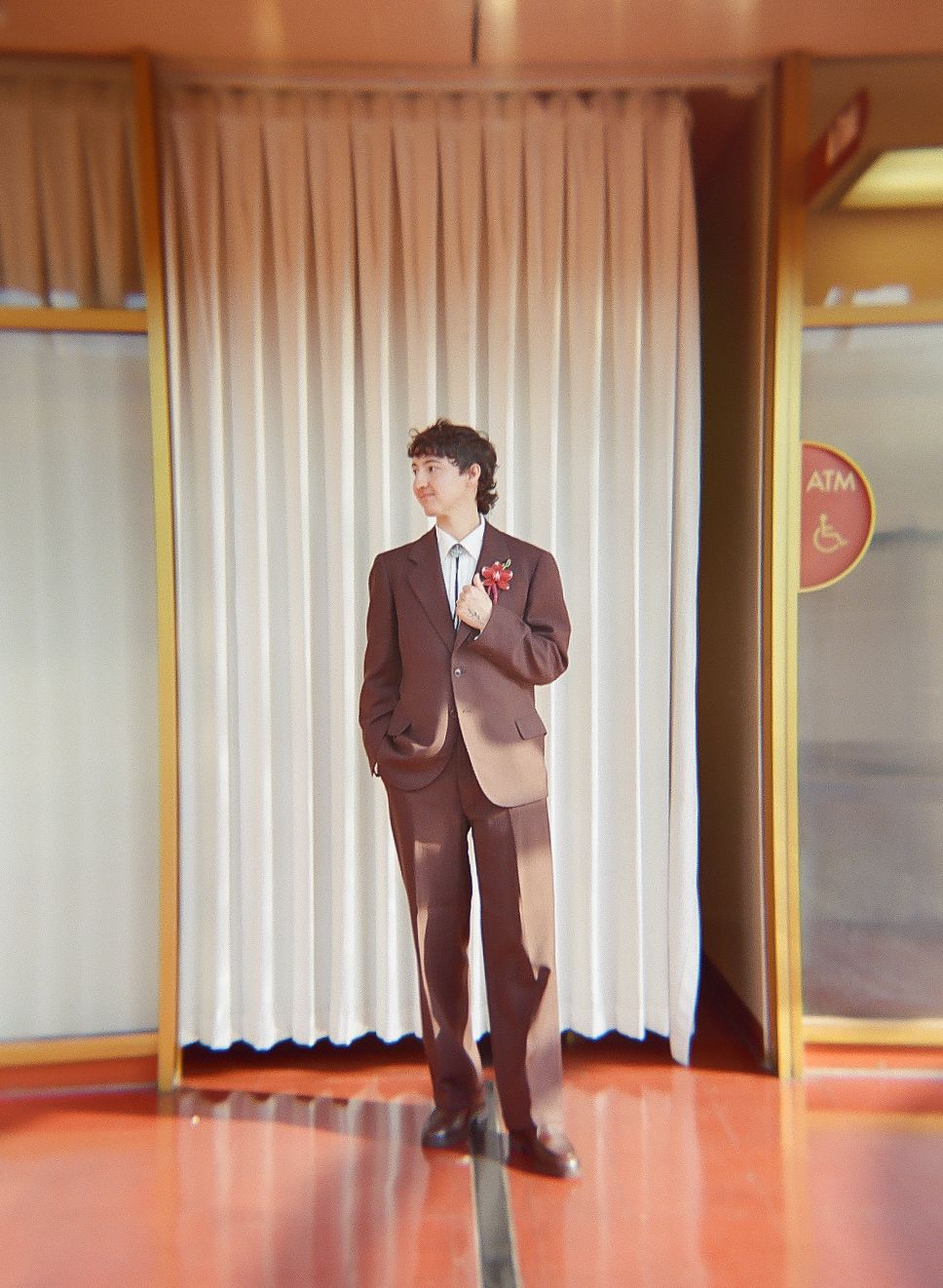 Brown suits and formal attire displayed in a room with orange flooring.