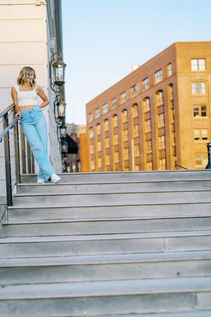 Urban fashion photography on concrete steps with brick buildings in background.