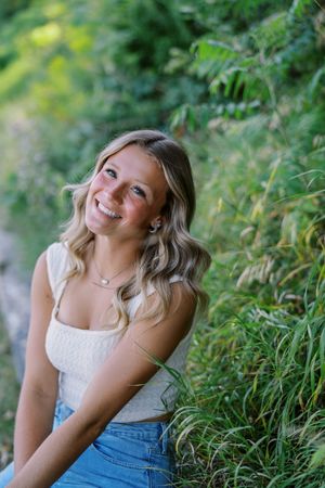 Summer portrait in nature with soft lighting and green foliage background.