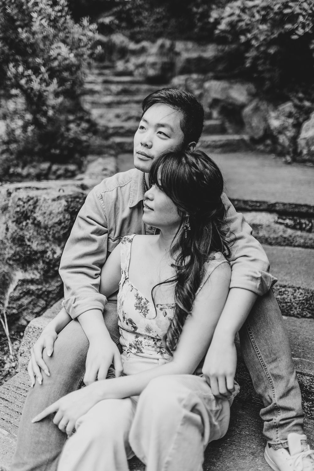 Black and white portrait of a couple sharing tender moments outdoors.
