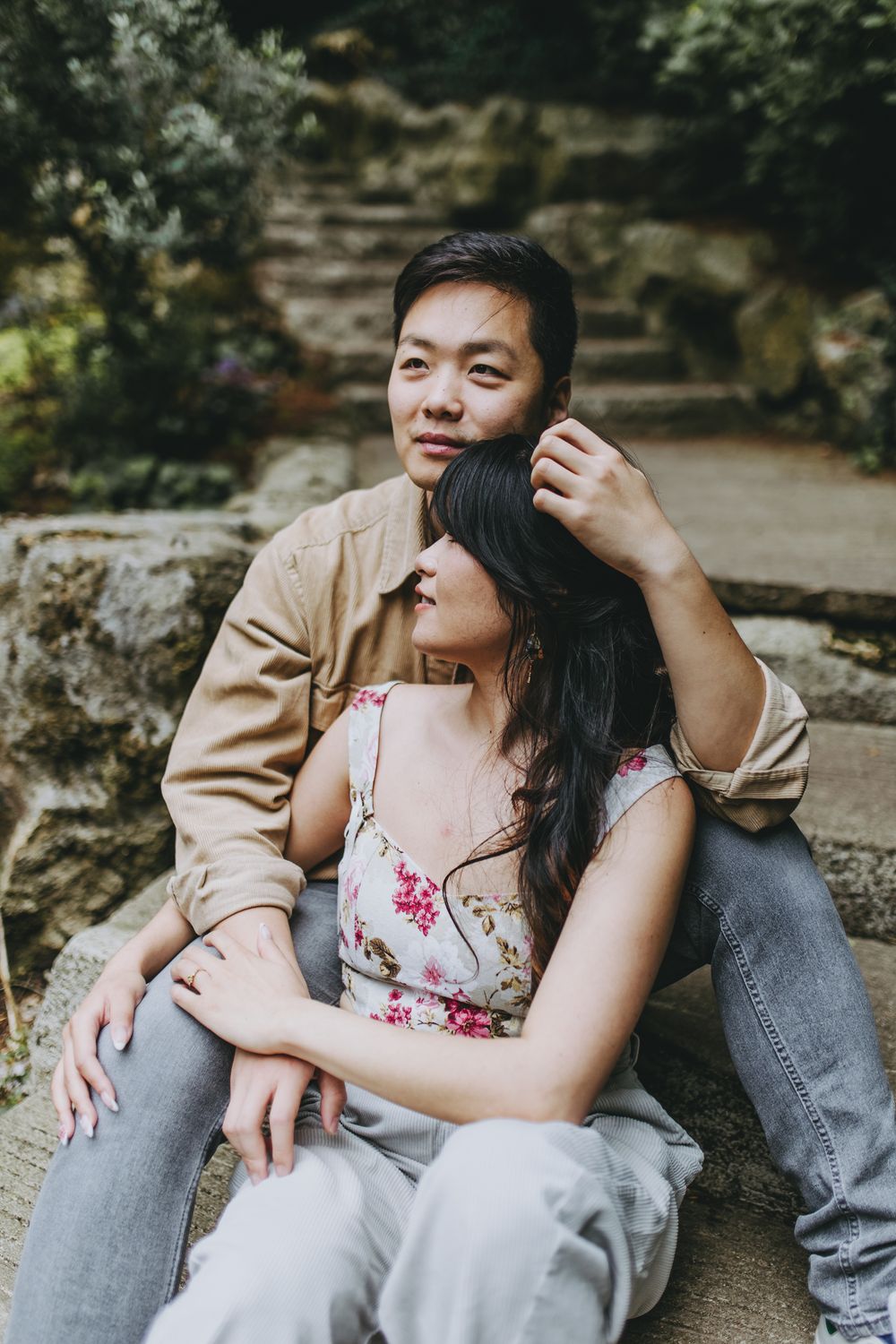 Intimate candid moments of a couple in casual wear sitting on stone steps.