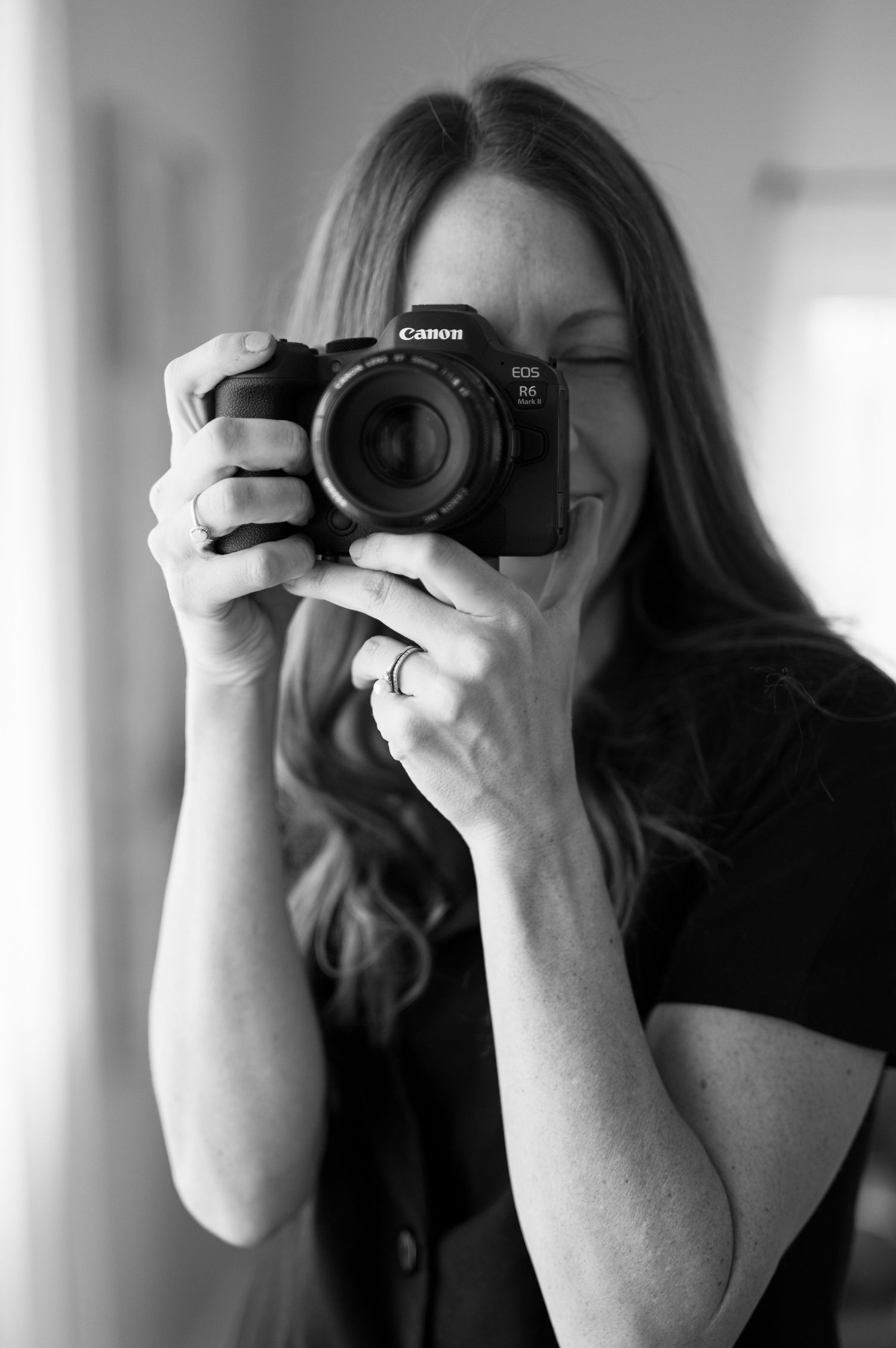 Black and white photo series of a photographer taking self portraits with a DSLR camera in different angles.