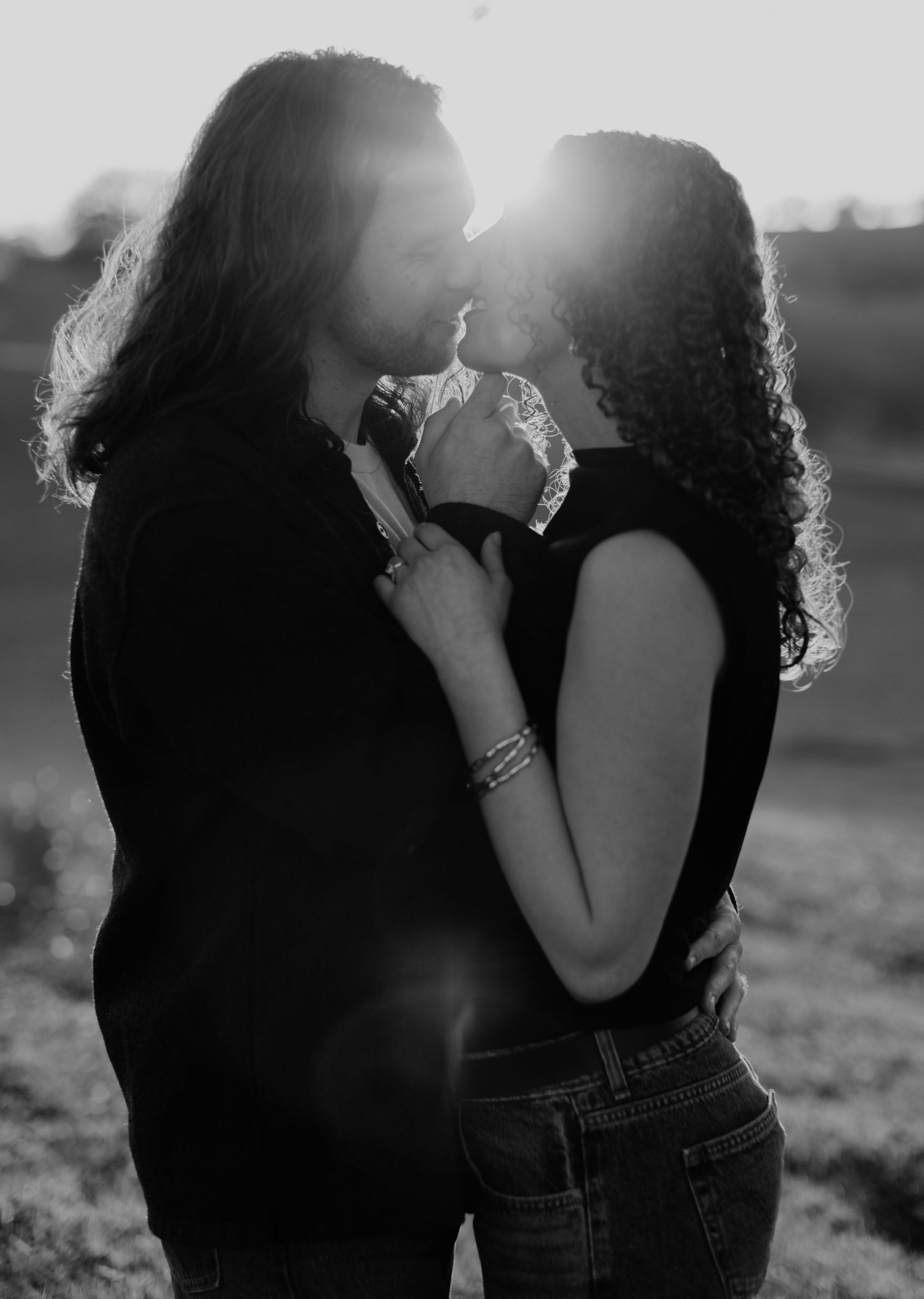 Black and white photo of couple sharing tender moment outdoors.