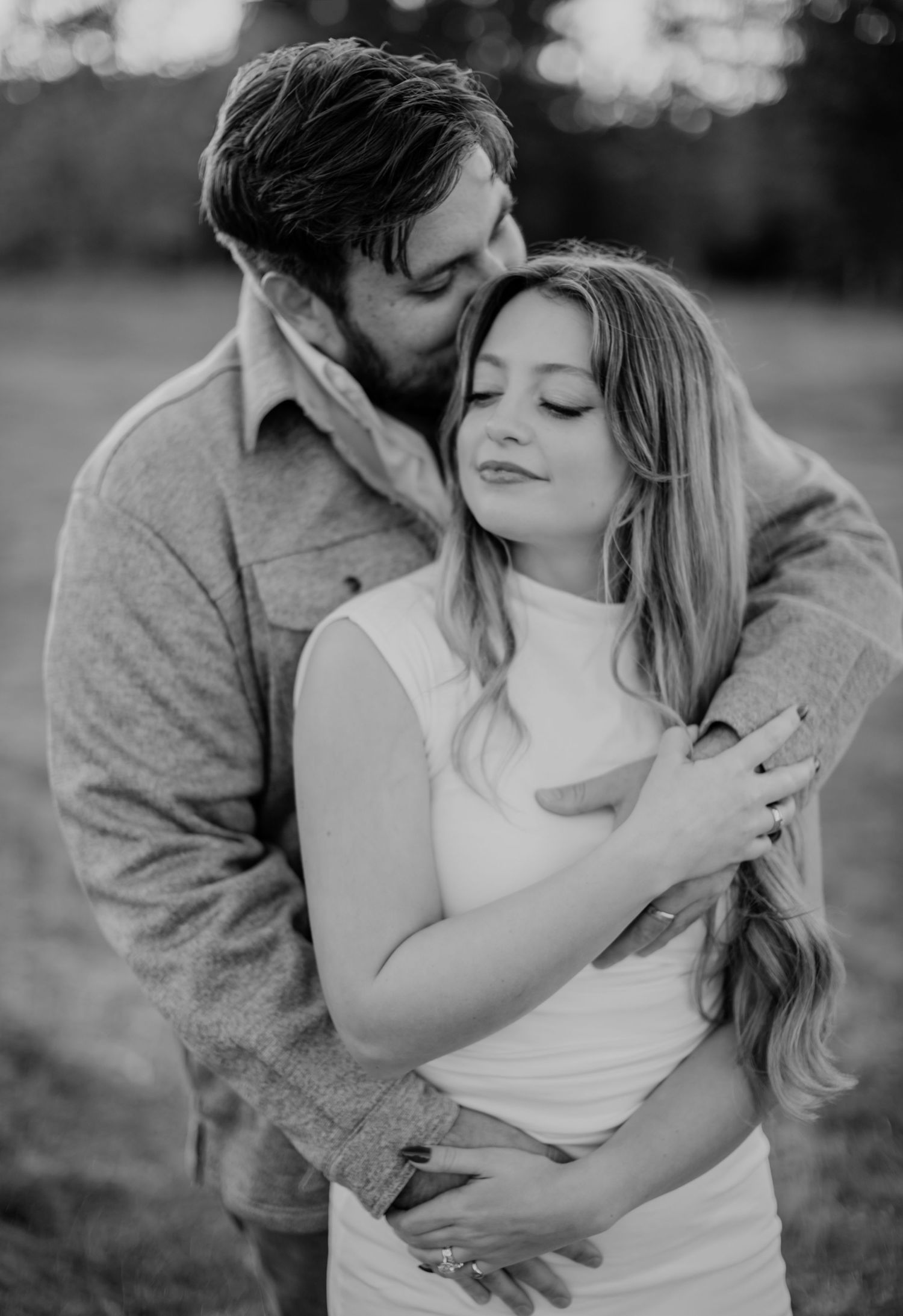 Romantic black and white photo series showing tender intimate moments between a couple embracing outdoors.