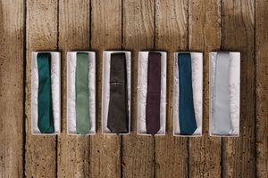 A row of vintage watercolor paint boxes arranged on rustic wooden planks showing various shades and colors.
