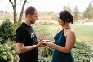 A couple shares an intimate moment together in a lush outdoor garden setting during a photo session.