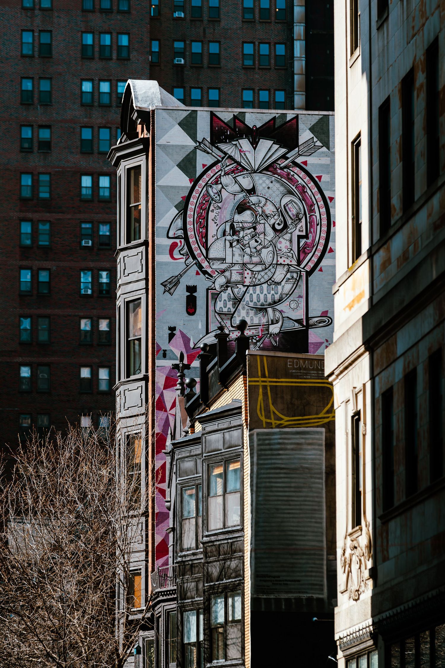 Large colorful street art mural on a building facade in an urban city setting with surrounding architecture.