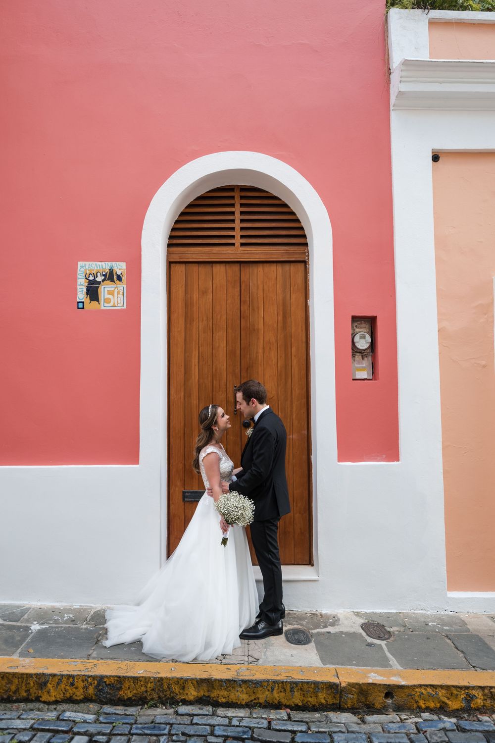 Bride and groom standing in front of colorful doorway during Old San Juan cocktail hour portraits