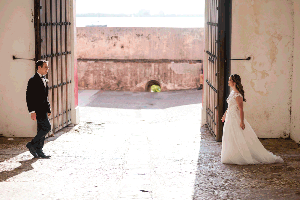 Bride and groom walking through historic doorway in Old San Juan during destination wedding