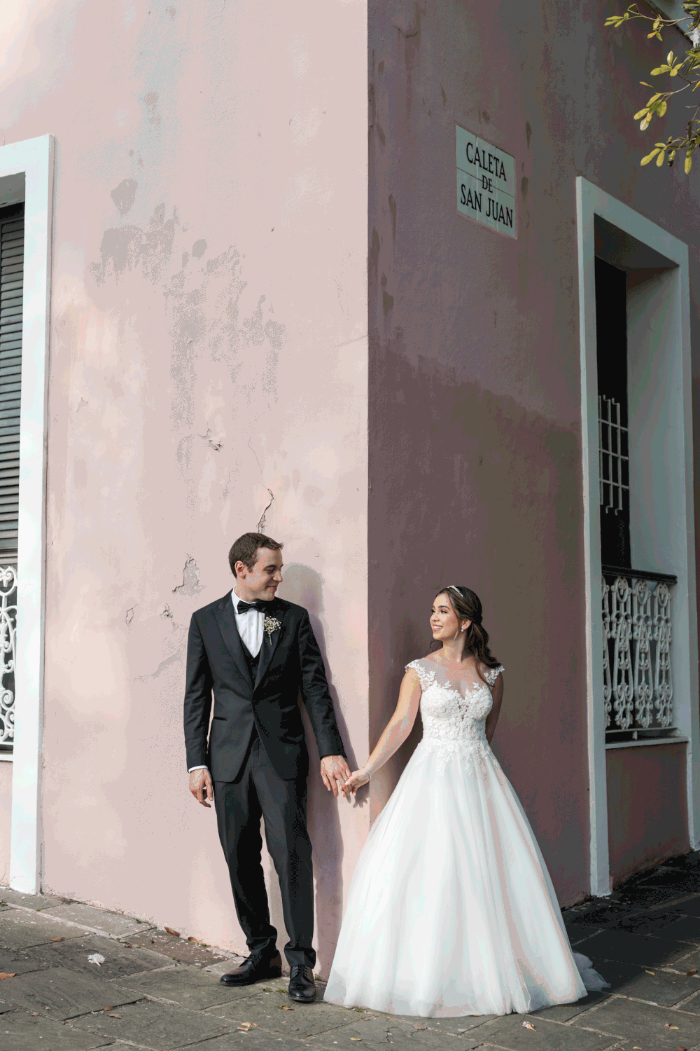 Bride and groom standing together against pastel wall in Old San Juan Puerto Rico