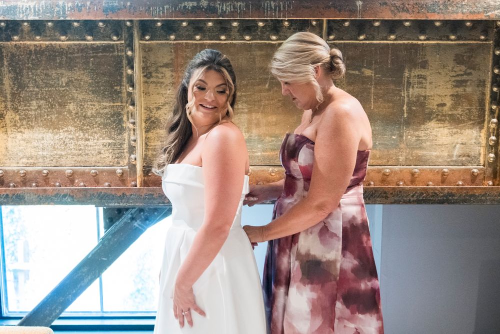 Couple sharing an intimate dance moment in an elegant indoor venue with rustic wooden walls.