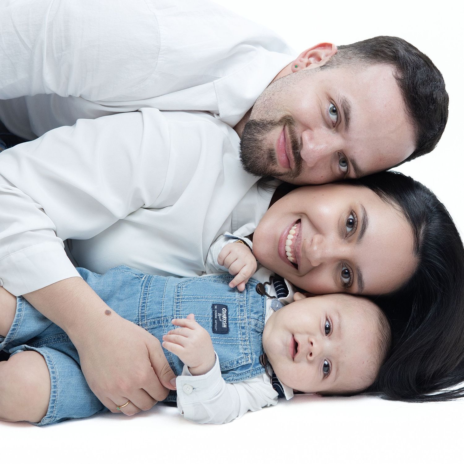 A couple lying together in casual attire, creating a series of intimate and playful poses for the camera.