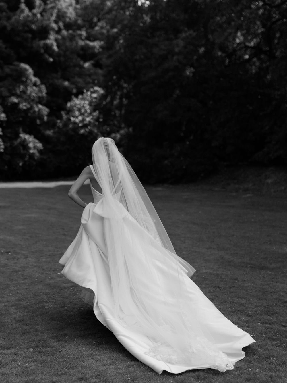 An ethereal white wedding veil floats gracefully in the breeze during an outdoor photo session.