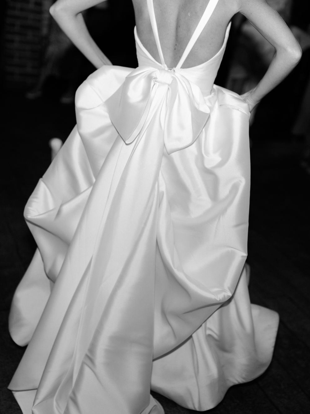 A series of white wedding dress details showing elegant ruffles and bow embellishments against a dark background.