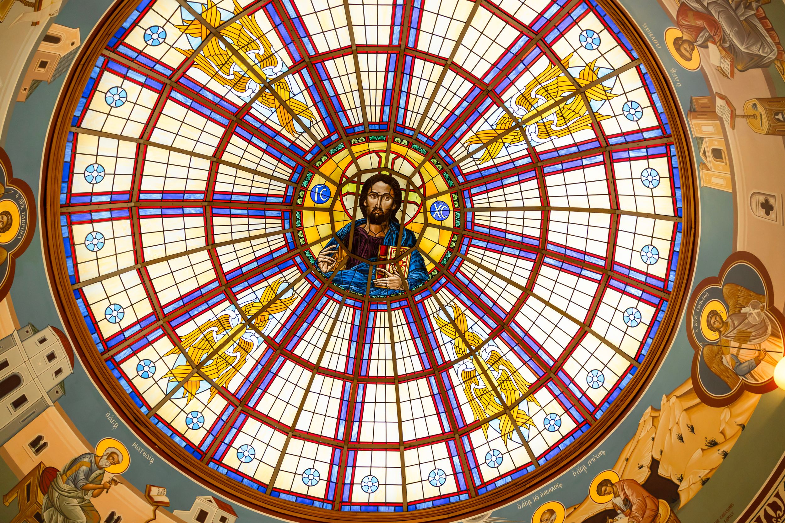Stunning stained glass dome ceiling featuring Jesus Christ in a colorful Byzantine style church.