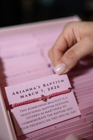 Pink baptism favor cards with komboskini bracelet keepsake for Arianna's Baptism on March 7, 2026.