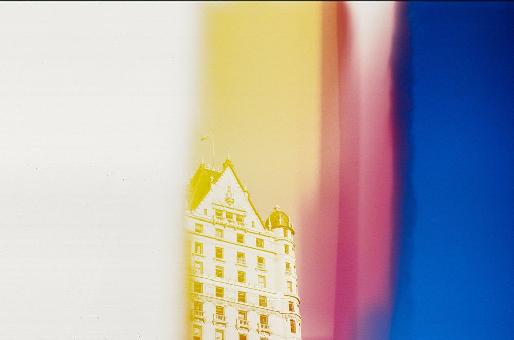 Yellow building facade photographed through colorful lens elements.