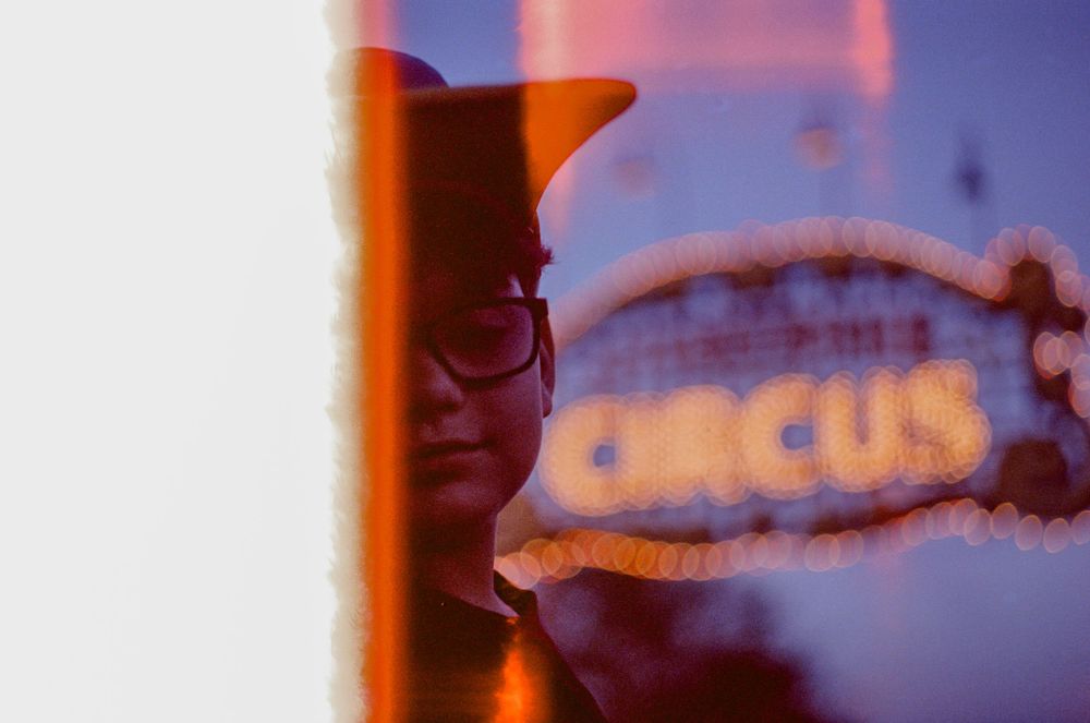 Blurred neon circus sign in twilight with atmospheric lighting.