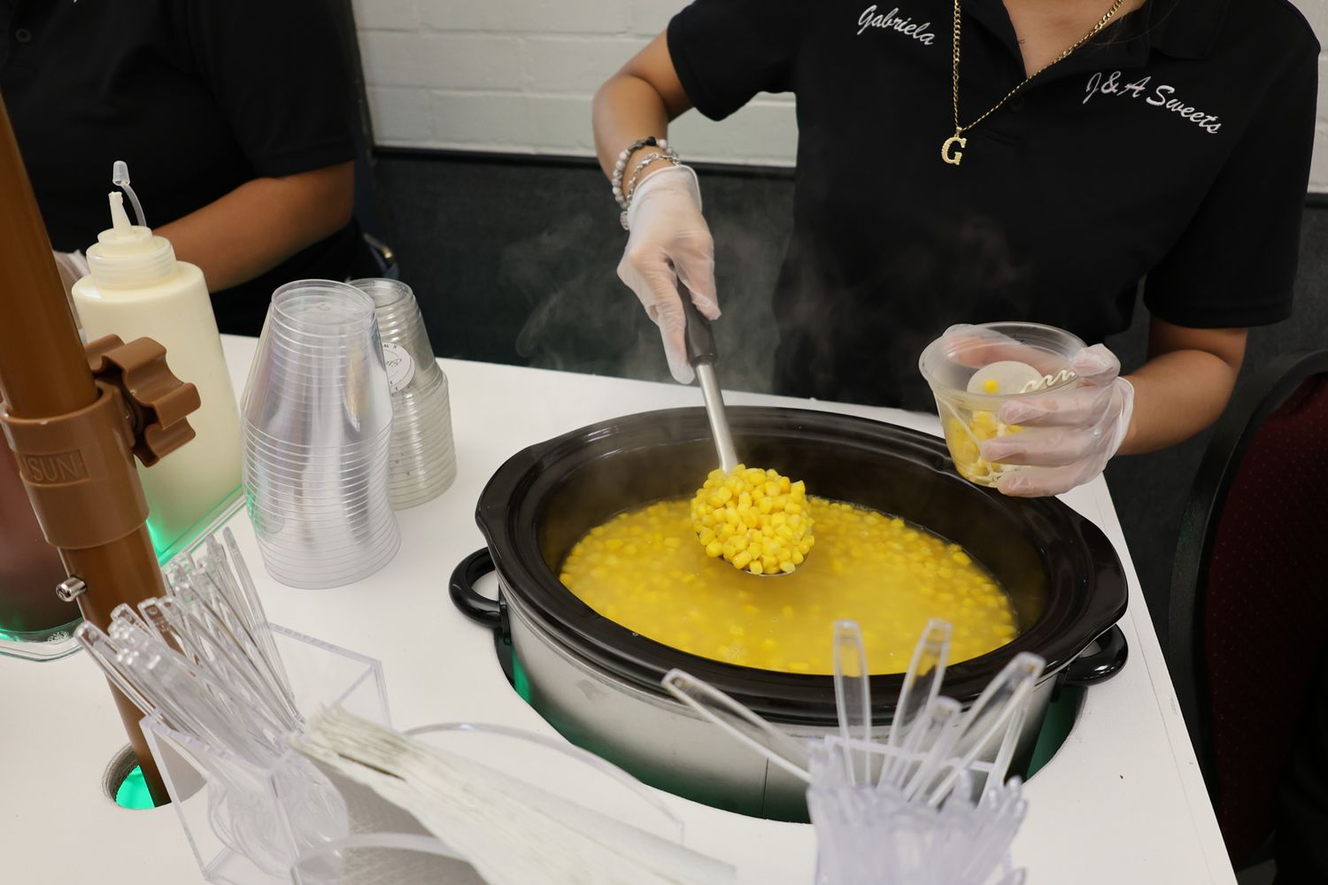 Food preparation station with staff working on yellow crepes or pancakes.
