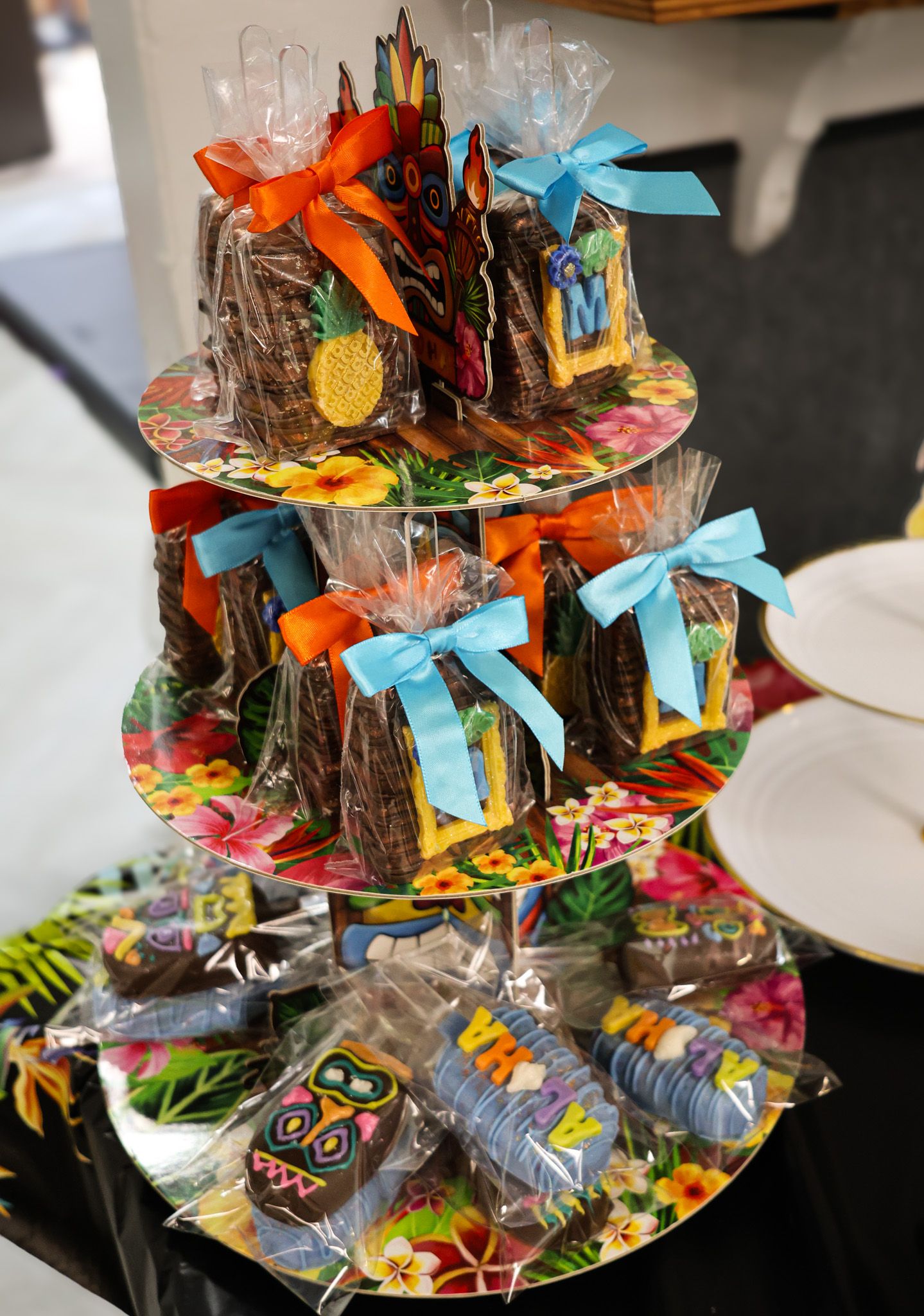 Colorful party favors and treats arranged on a tiered display with blue ribbons and festive packaging.