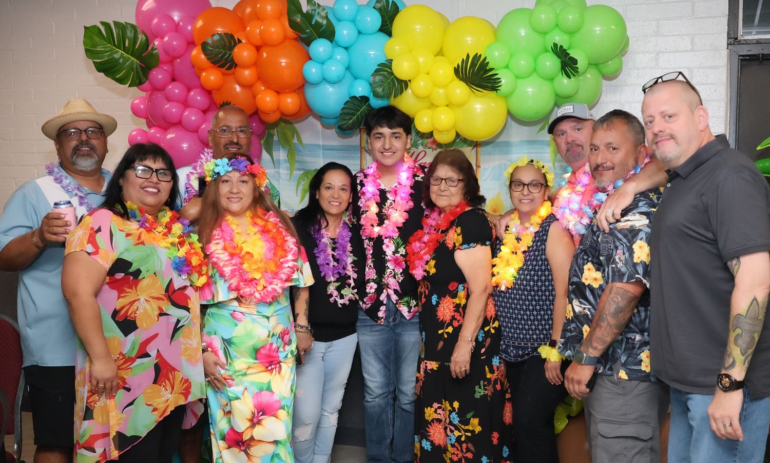 Vibrant rainbow colored balloons create a festive arch display at a celebration.