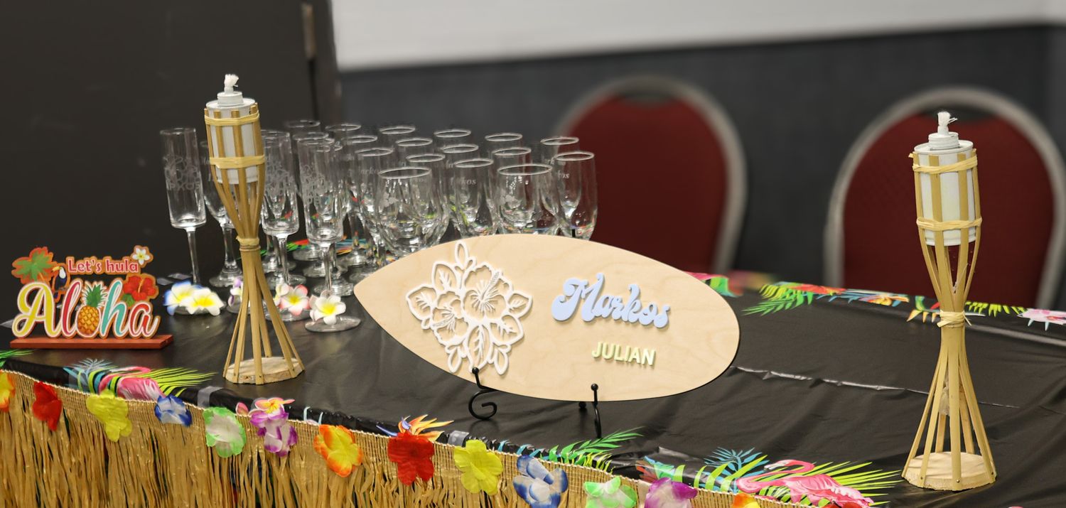 Party setup with drinks and decorations on a dark table with ambient lighting.