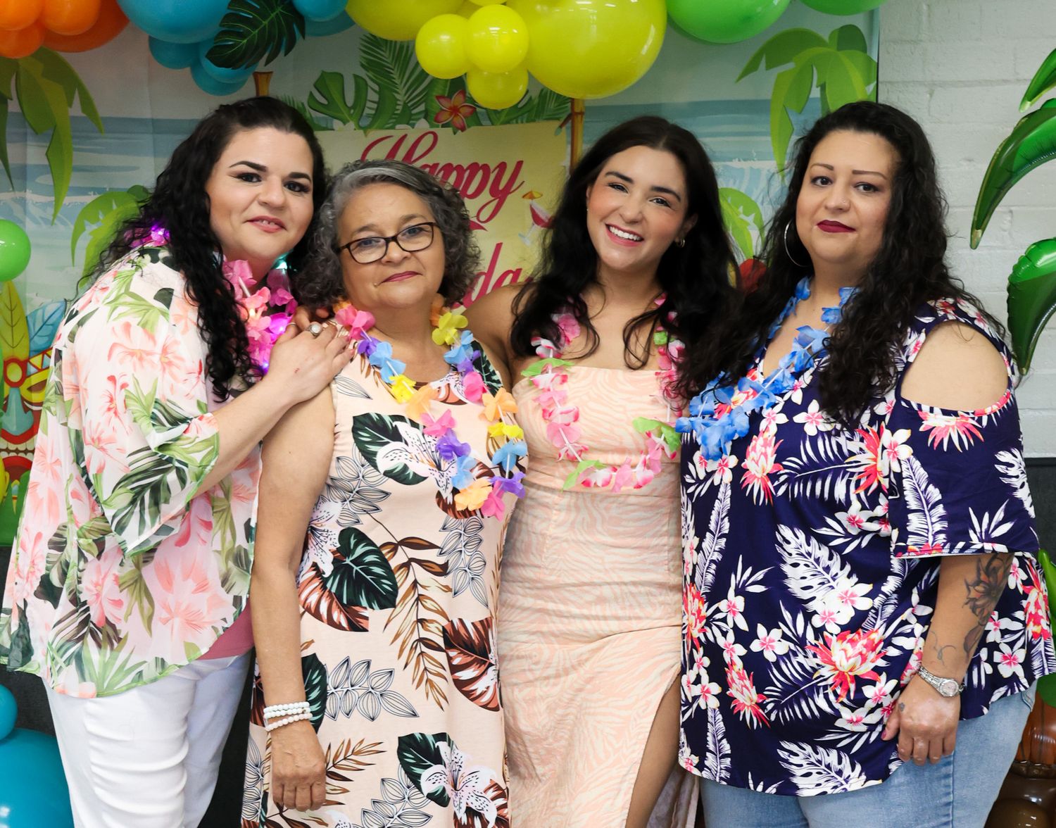 Tropical themed party decorations with colorful balloons and palm leaf accents.