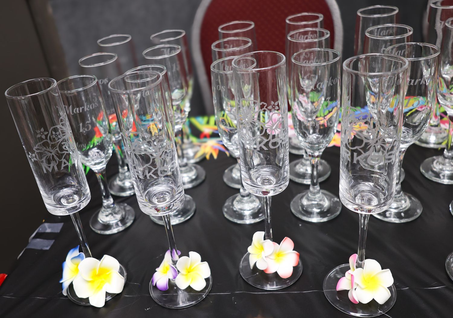 Clear plastic party cups lined up on display with floral decorative elements.