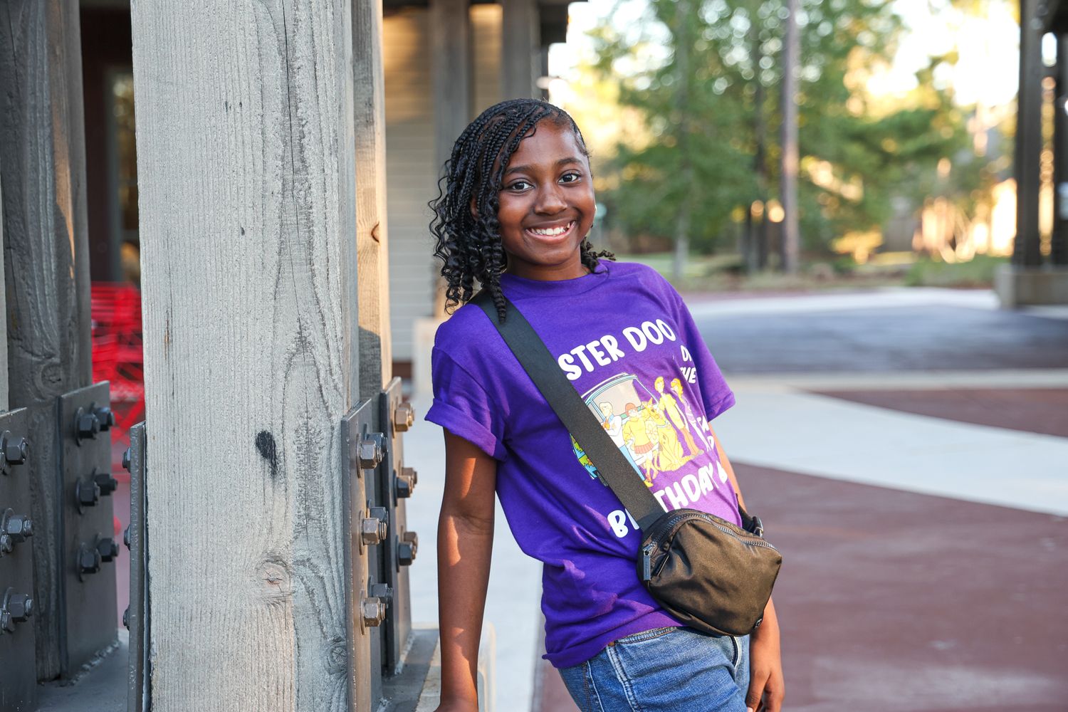 People wearing purple shirts gathered outdoors on a sunny day.