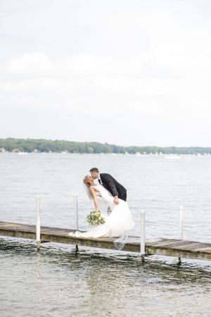 groom dipping bride on dock