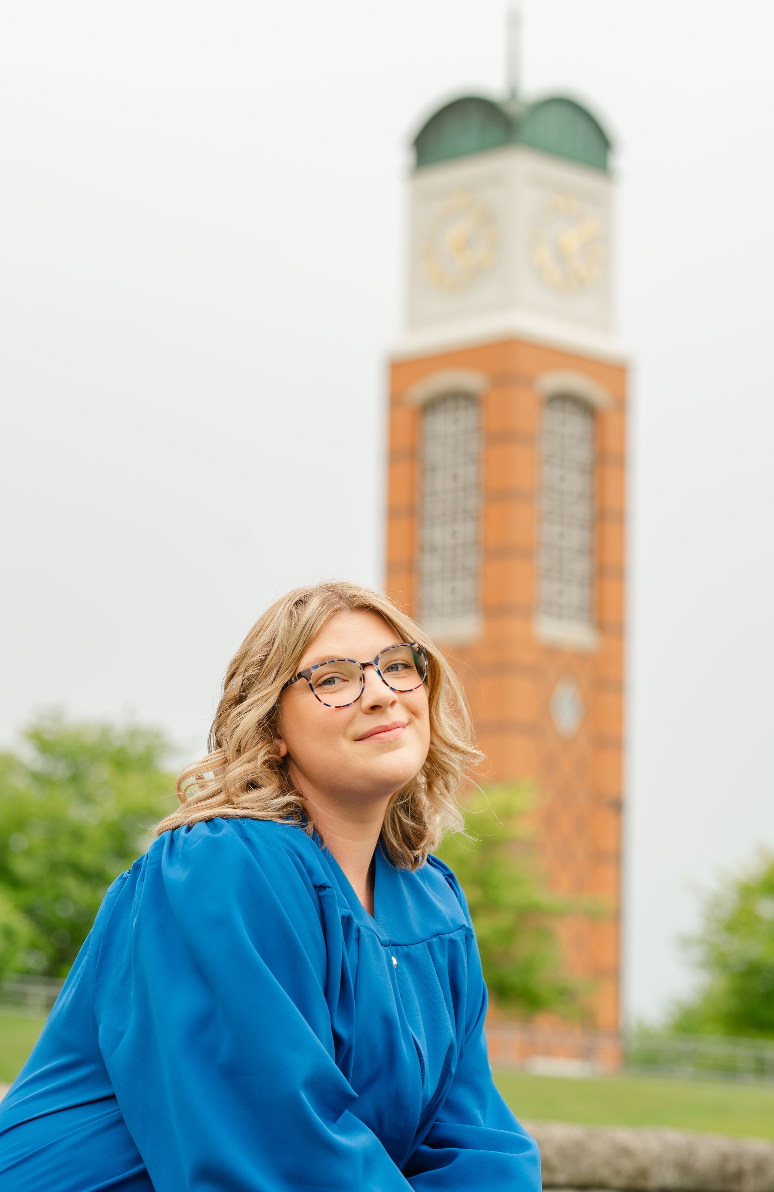 senior smiling in front of gvsu clock tower