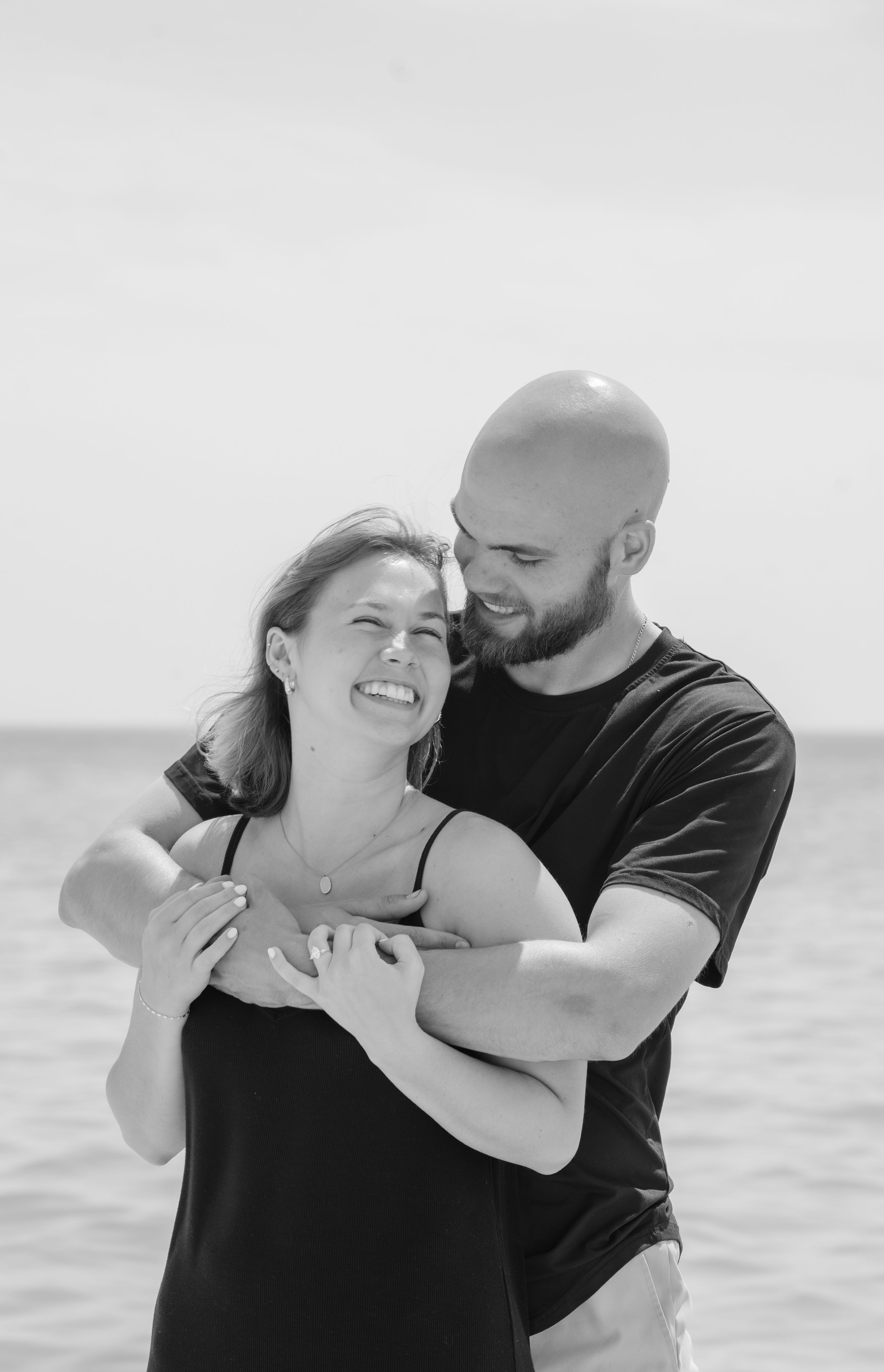 couple holding each other in front of beach