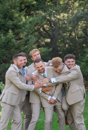groomsmen hugging the groom