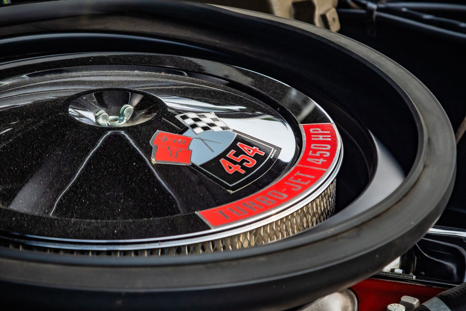 Close-up detail of a black car engine air filter with red accents.