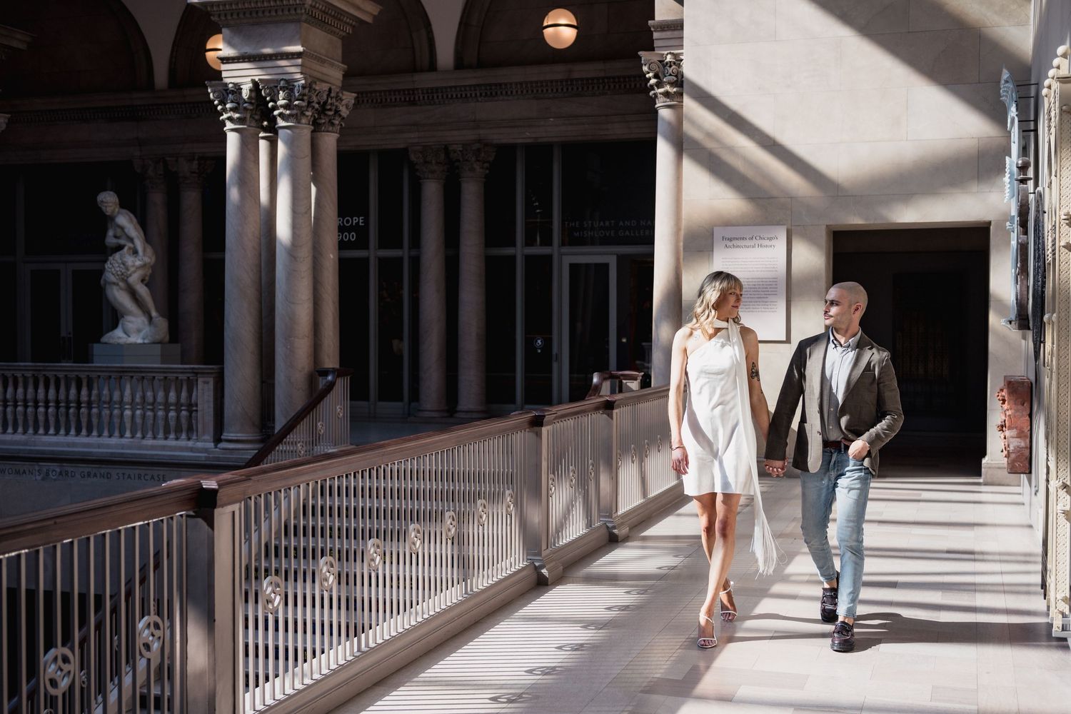 Engagement photo of couple walking through the Art Institute in Chicago.