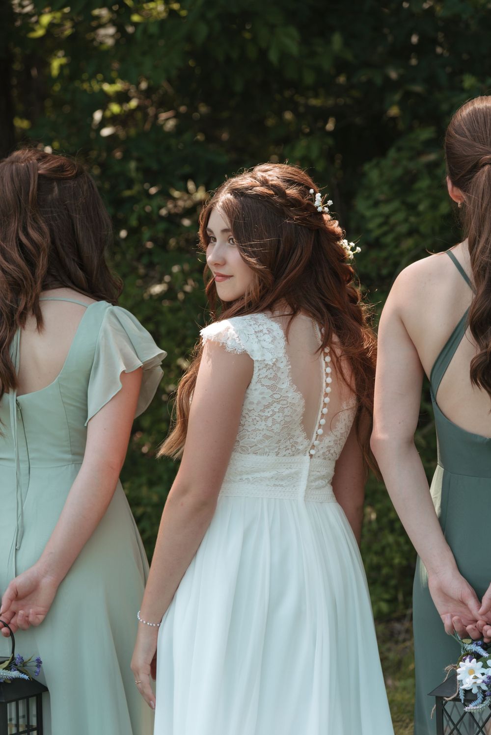 Bridesmaids in mint green and white dresses lined up at outdoor wedding ceremony.