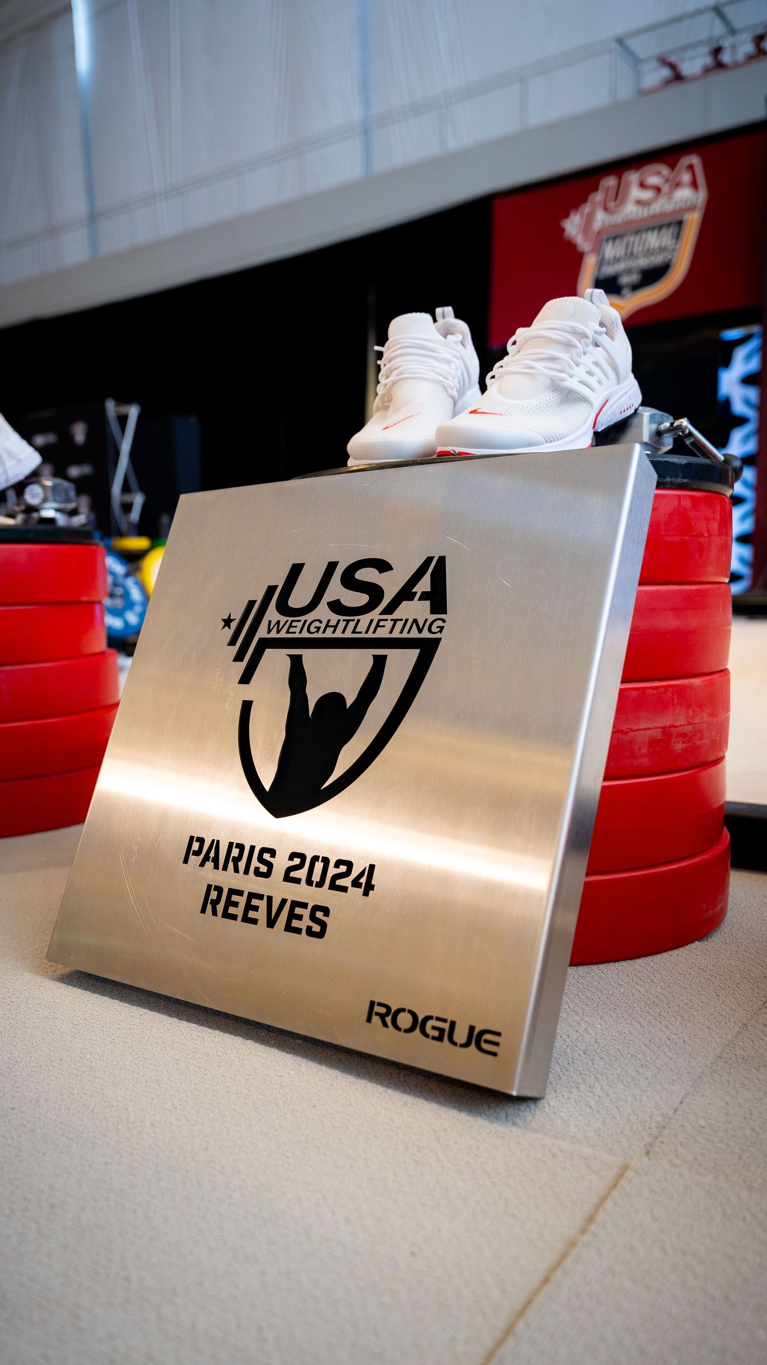 USA Weightlifting Paris 2024 commemorative plaque with white shoes displayed on top.