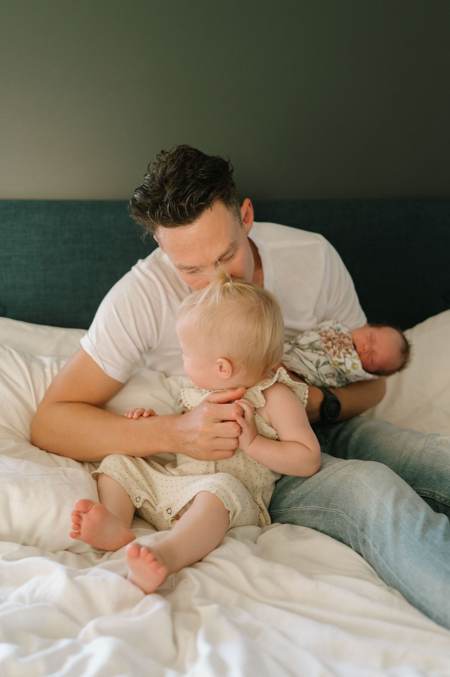 An intimate family moment captured on a bed as a parent bonds with their children.