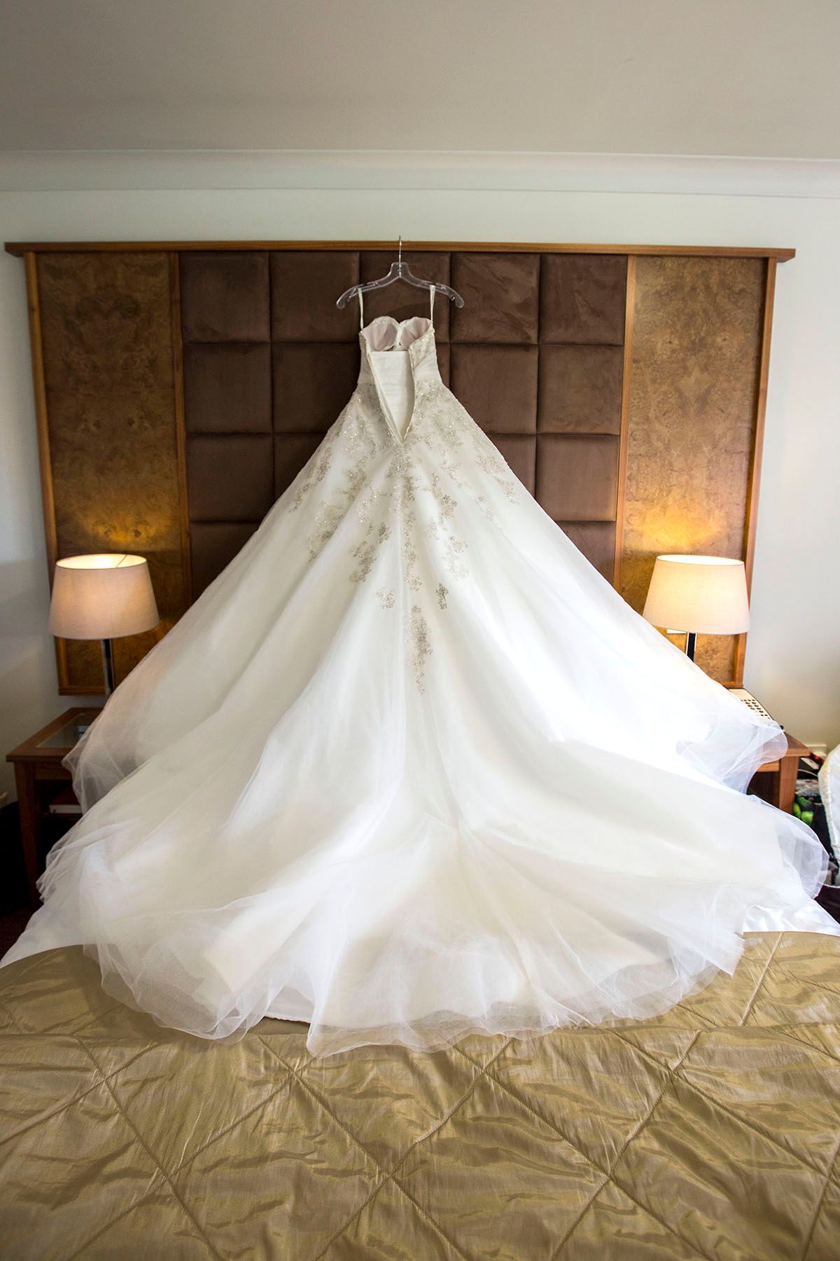 Weddin dress hanging up above the bed, at eastwoon hall hotel