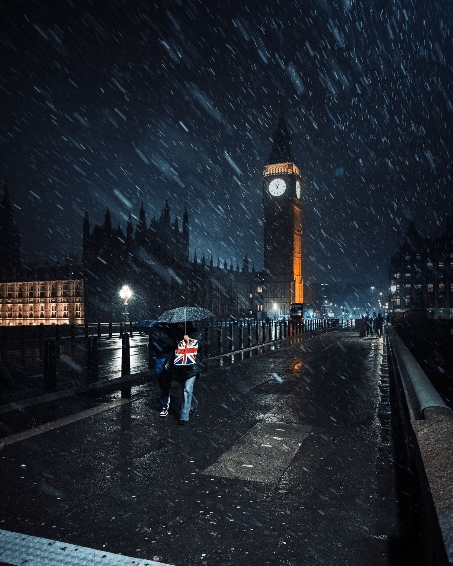 Snowy night view of Big Ben clock tower illuminated in gold against dark London sky.