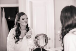 Wedding preparation moments captured in elegant white interior setting.