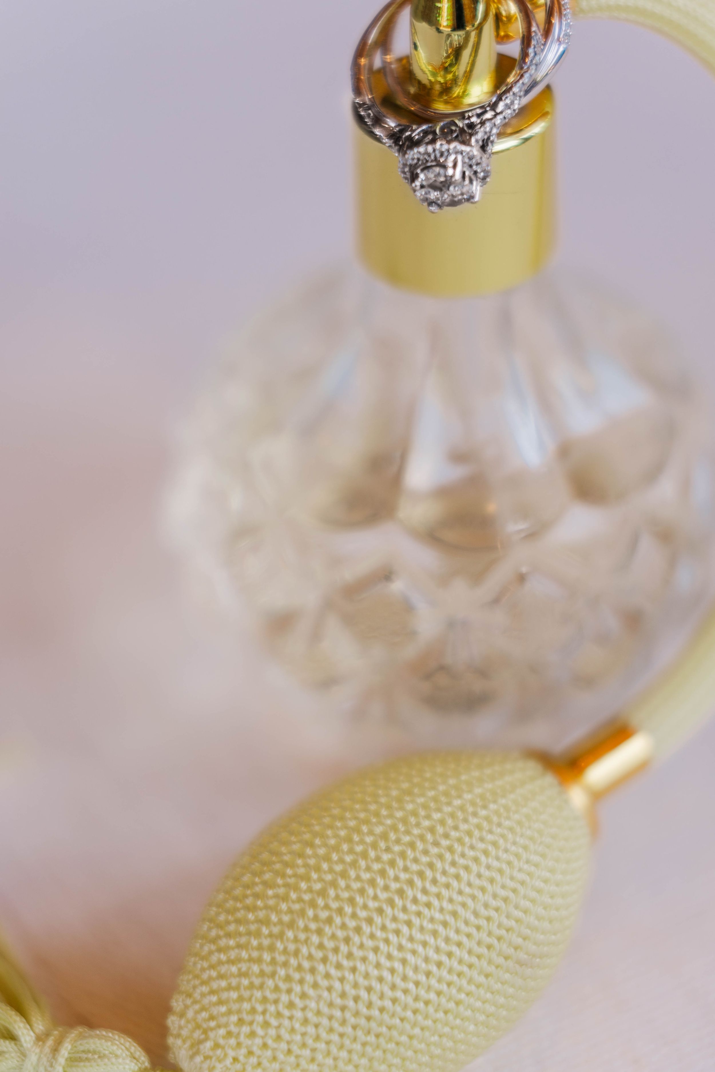Close-up of perfume bottle and bridal accessories with soft focus.
