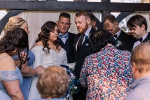 Wedding guests gathered for celebration under covered outdoor venue.