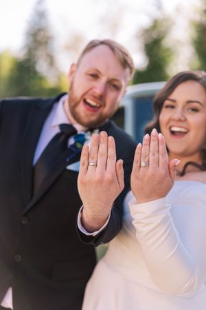 A wedding couple shows off their rings with a playful series of hand poses.