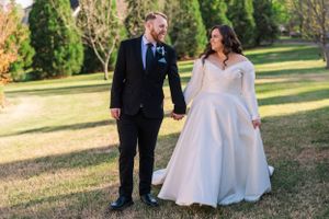 Beautiful outdoor wedding photography showing the couple walking together on grassy grounds.