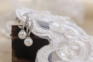 Close-up of intricate white lace trim with delicate pearl details.