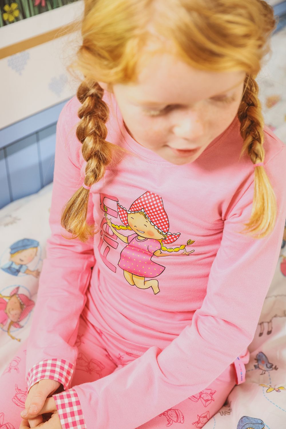 Close-up of pink pajama top with fairy character design and gingham detail.
