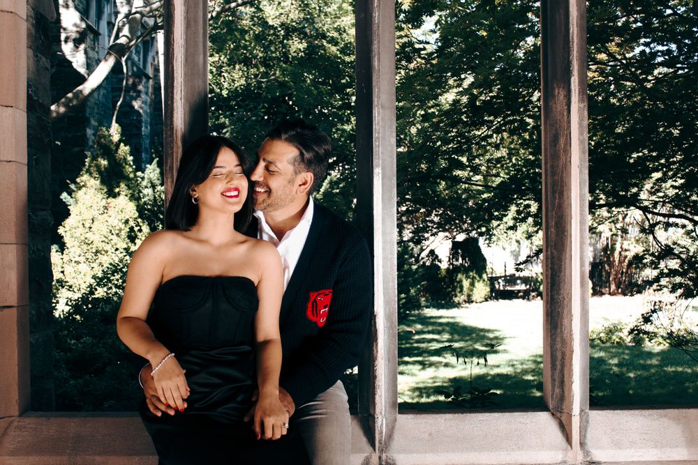 Couple sharing intimate moment in stone architectural alcove with garden view.