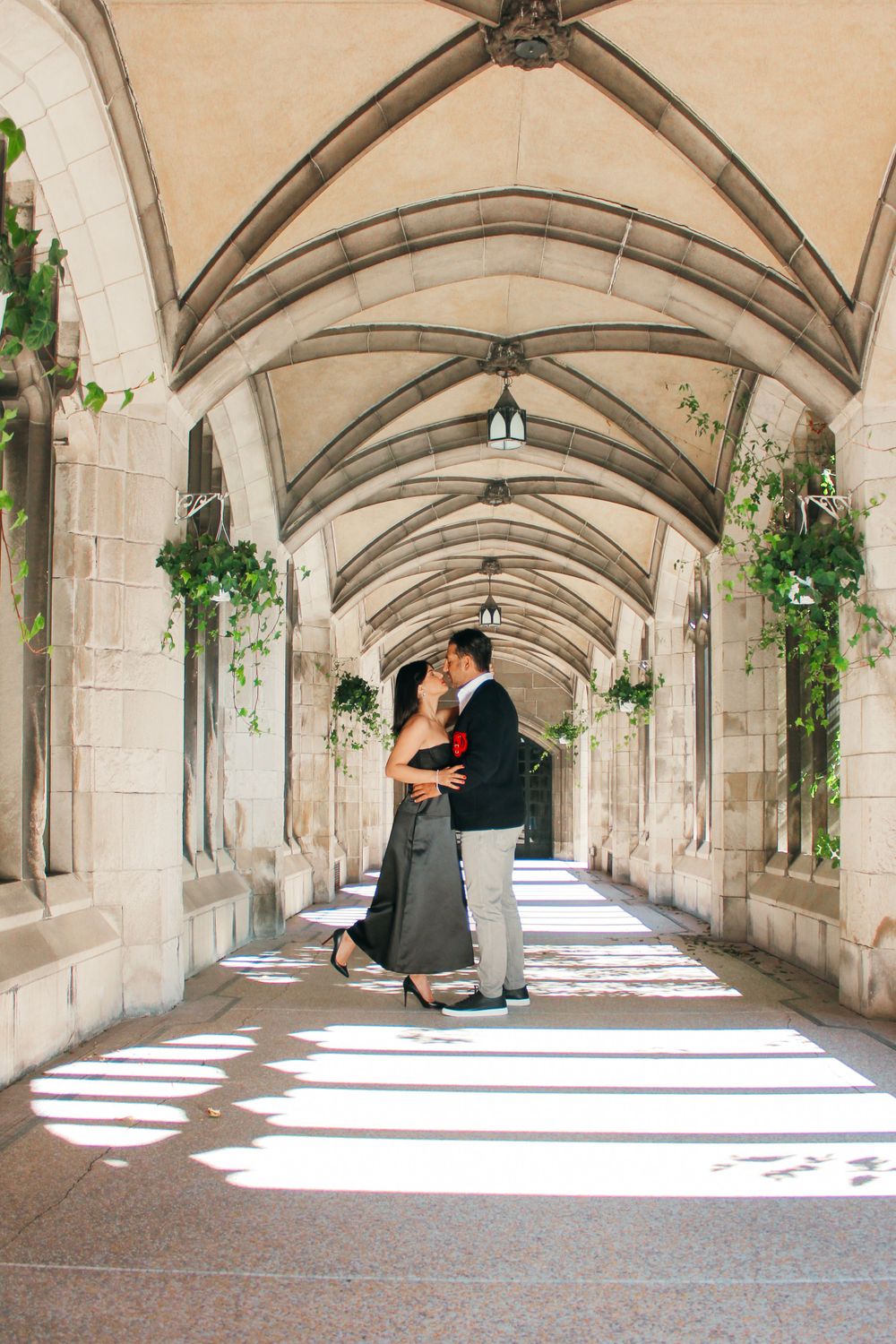 A couple sharing an intimate dance in a sunlit gothic archway passage.